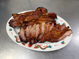 Sliced and whole Cantonese BBQ pork on a decorative plate.
