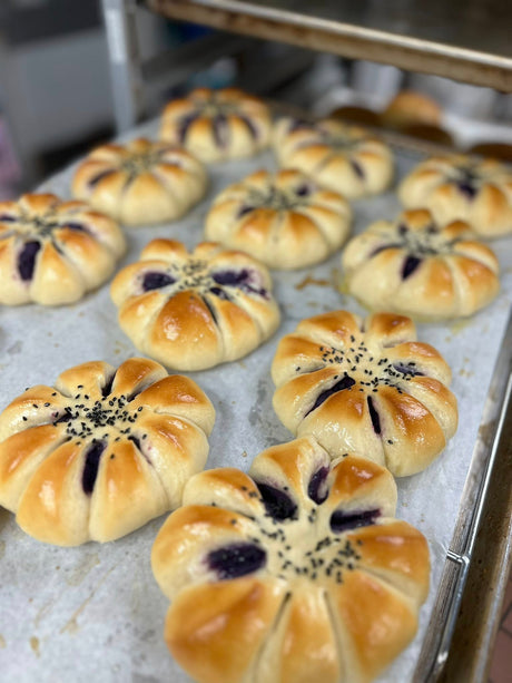 Baked pastries with sweet ube filling on a baking tray